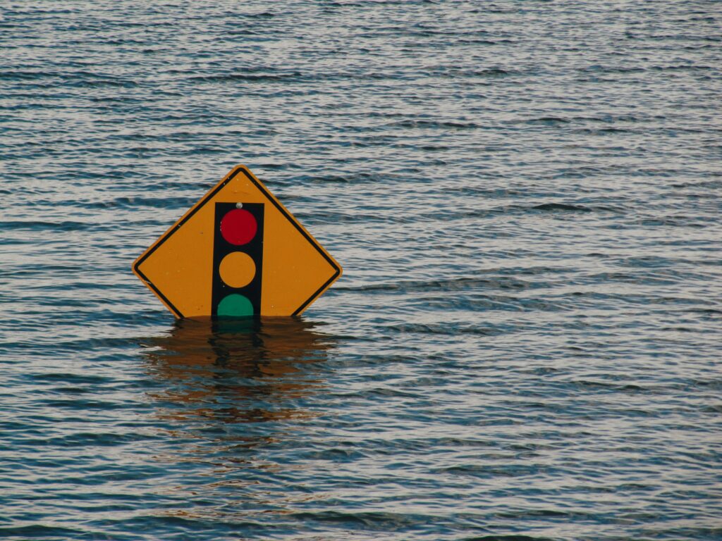 A traffic light sign submerged in water in a flood